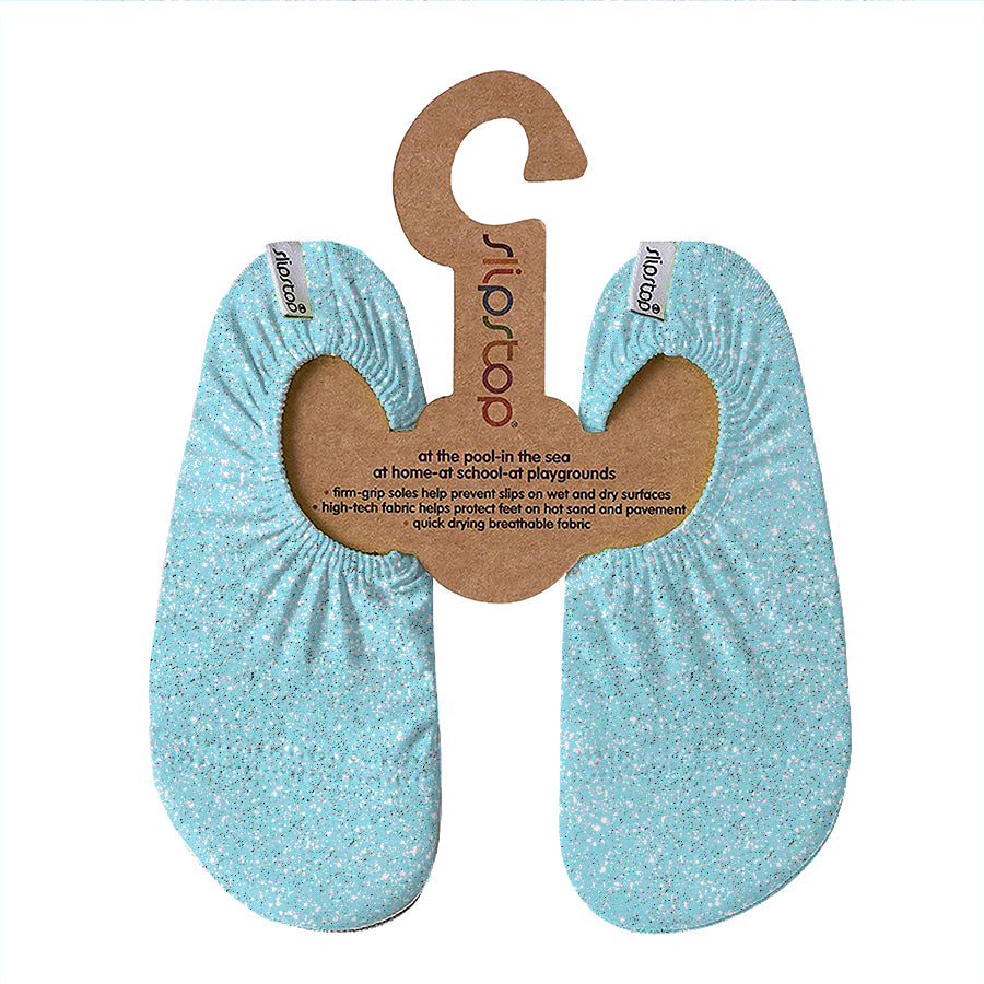 A pair of blue Slipstop water shoes for kids, displayed on a cardboard hanger with product information.